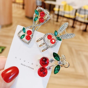 Mini red cherry hair claw clips set with sparkling rhinestones on golden metal base
