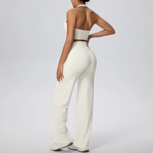 Detail of halter neck sports top and high-waisted wide-leg yoga pants set in beige