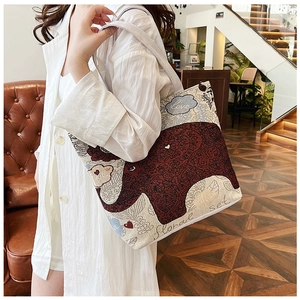 Close-up of ethnic jacquard canvas tote bag with woven animal pattern and embroidered text