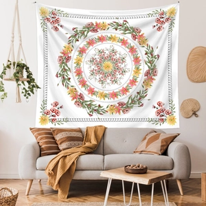 Floral wreath wall tapestry hanging over a grey sofa in a cozy minimalist room