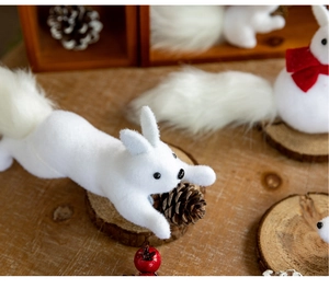 Detailed close-up of white flocked squirrel ornament with realistic fur texture and pine cones