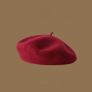 Close-up detail of high-quality wine red wool fabric texture on a vintage beret hat