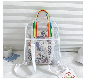 Detailed view of clear PVC backpack featuring colorful rainbow straps on white bedding