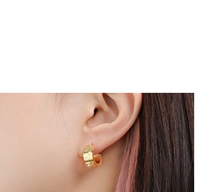 Close-up of gold geometric hoop earrings with sparkling white crystals on model