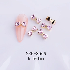 Macro view of pink heart rhinestone bow nail charms with 9.5x4mm dimension detail
