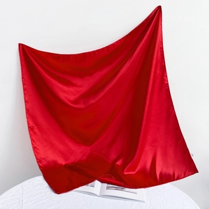 Close-up of vibrant red satin silk square scarf with glossy finish and elegant drape