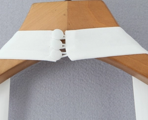 Détail des boutons recouverts de tissu et des boucles au dos d'une robe blanche en coton