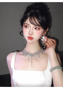 Luxurious silver necklace and earring set with waterdrop crystals worn by a model