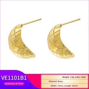 Detail view of golden C-shape brass earrings featuring classic quilted texture and polished finish