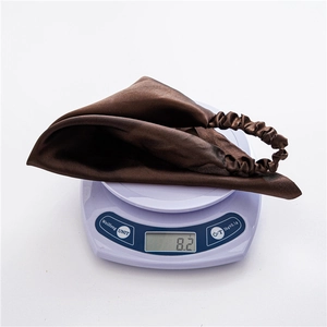 Detail shot showing the lightweight 8.2g dark brown satin headscarf on a digital scale