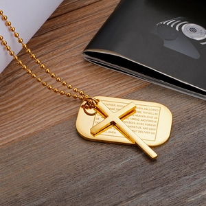 Détail du pendentif croix et plaque carrée avec gravure Notre Père sur chaîne à billes dorée