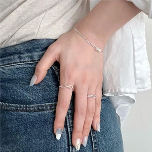 Close-up of S925 sterling silver pearl bracelet and geometric rings set on a model hand
