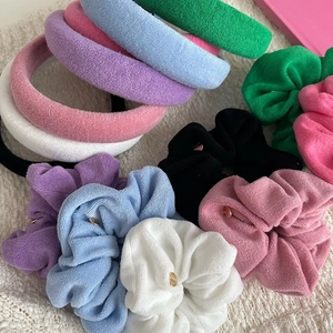 Flat lay of colorful terry cloth headbands and hair scrunchies in various soft pastels