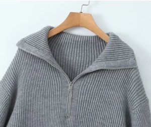 Détail d'un pull en maille grise avec col montant zippé et texture à grosses mailles