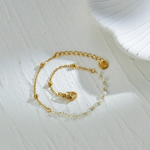 Detailed shot of 14K gold plated stainless steel bracelet with white pearls and beads