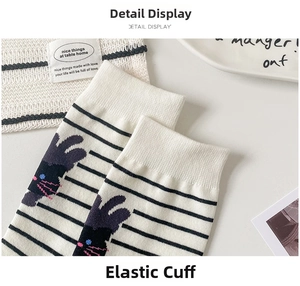 Detail view of elastic striped sock cuffs featuring cute dark cat embroidery patterns