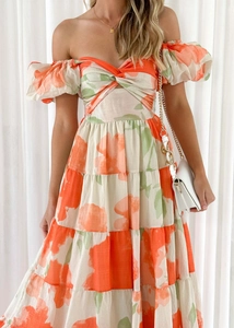 Detail of floral print off-shoulder dress with puff sleeves and orange flower pattern
