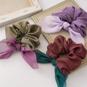 Three plaid scrunchies with chiffon bow streamers on a white decorative background