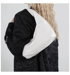 Close-up of white glossy hobo bag with stylish pleated texture and rivet details