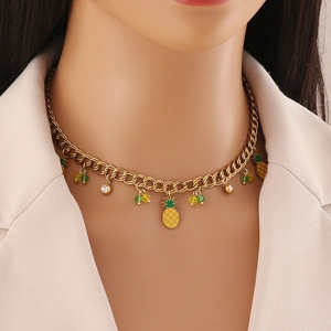 Golden chain necklace with pineapple pendant and yellow beads worn by model