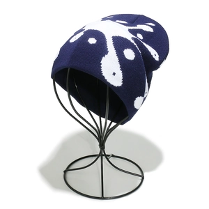 Close-up of the ribbed knit texture and white splatter jacquard pattern on a navy beanie