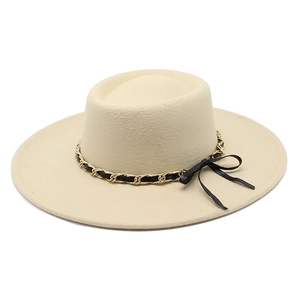 Detail of light beige wool felt fedora featuring a gold chain and black bow band decoration