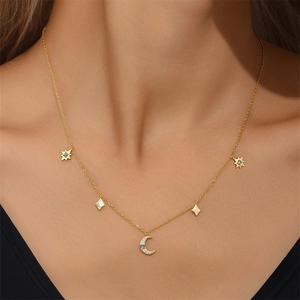 Detailed view of gold necklace with star and moon charms and inlaid blue opals