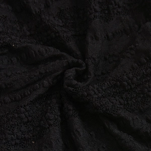 Detailed macro shot of high-quality black lace fabric with intricate floral embroidery
