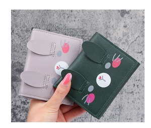 Detailed view of gray and green tri-fold short wallets with cute cartoon rabbit design