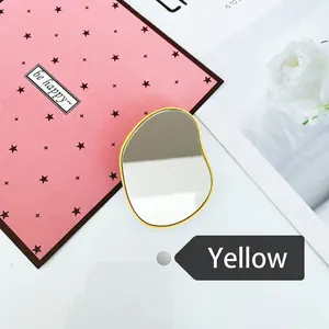 Close-up of a yellow irregular folding mirror stand on decorative star background