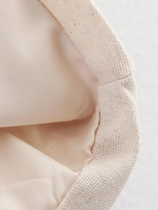 Close-up of beige cotton linen fabric set showing refined stitching and smooth lining texture