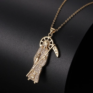 Vue détaillée du pendentif Santa Muerte doré orné de cristaux blancs étincelants