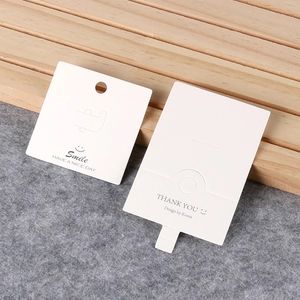 White cardboard jewelry display cards for earrings and necklaces with Smile print