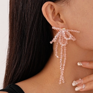 Close-up of elegant pink beaded tassel earrings on model with high fashion style