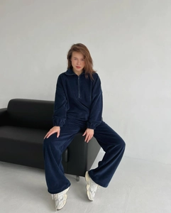 Détail d'un survêtement en polaire bleu foncé avec col zippé et pantalon décontracté