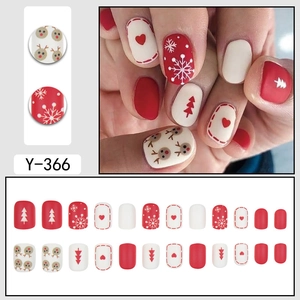 Cute Christmas press-on nails with red reindeer, white snowflake, and heart patterns