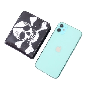 Short bi-fold wallet for men with skull print next to a phone for size reference