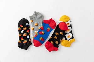 Detail view of colorful cotton socks with hamburger, beer, fries and egg food patterns