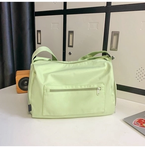 Détail d'un sac de sport vert clair avec poche zippée et bandoulière large