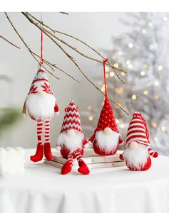Detailed view of four red and white knitted Christmas gnomes hanging on wooden branches