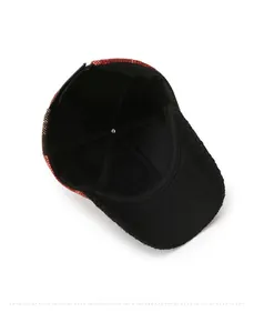Detail view of red and black plaid baseball cap with inner lining and brim embroidery