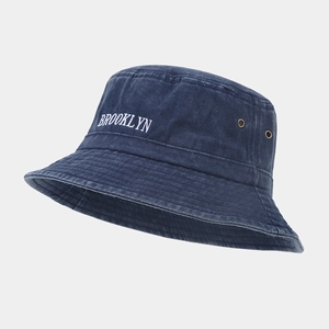 Détail de la broderie Brooklyn et des œillets sur le chapeau bob bleu délavé