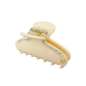 Dettaglio del mollettone bianco crema con strass e lettera D in metallo dorato