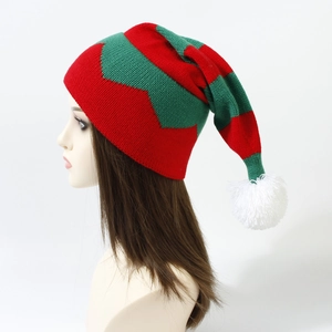 Detail of red and green knitted Christmas long tail hat with white pom-pom and wave texture
