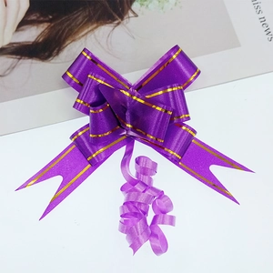 Detailed view of purple gift ribbon bow with gold edges for festive packaging