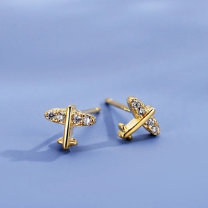 Cute gold mini airplane stud earrings with white zircons for women on a blue background
