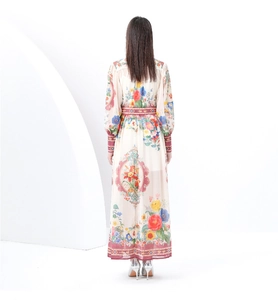 Back view of a long floral print dress with lantern sleeves and waist belt on a model