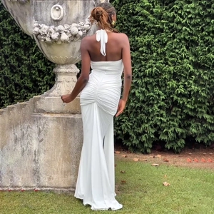 Vue arrière d'une robe longue blanche dos nu avec d'élégants détails plissés au dos