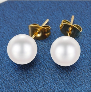 Primer plano de elegantes pendientes de acero 18K con perlas blancas brillantes