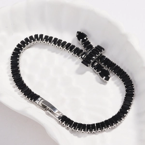 Detail view of black rectangular zircon tennis bracelet on decorative shell tray